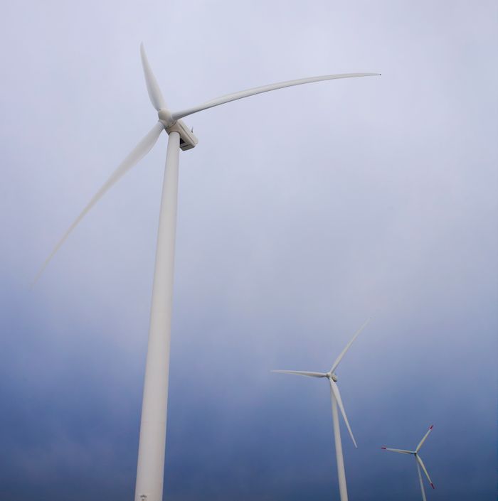 Wind turbines generating clean energy against a cloudy sky backdrop.